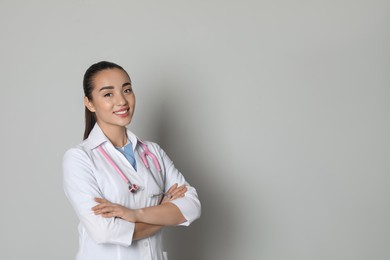 Photo of Portrait of beautiful young doctor on light grey background. Space for text