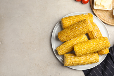 Photo of Delicious boiled corn served on light grey table, flat lay. Space for text