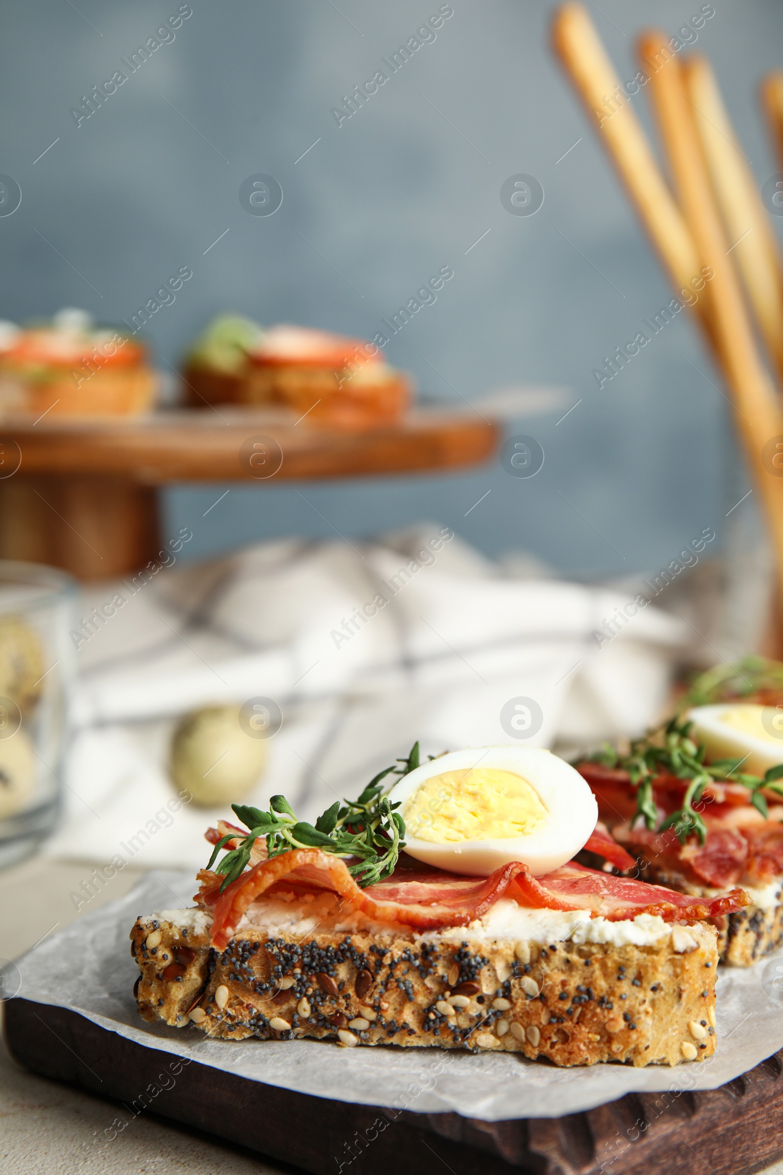 Photo of Cutting board of delicious bruschettas with prosciutto on table, space for text