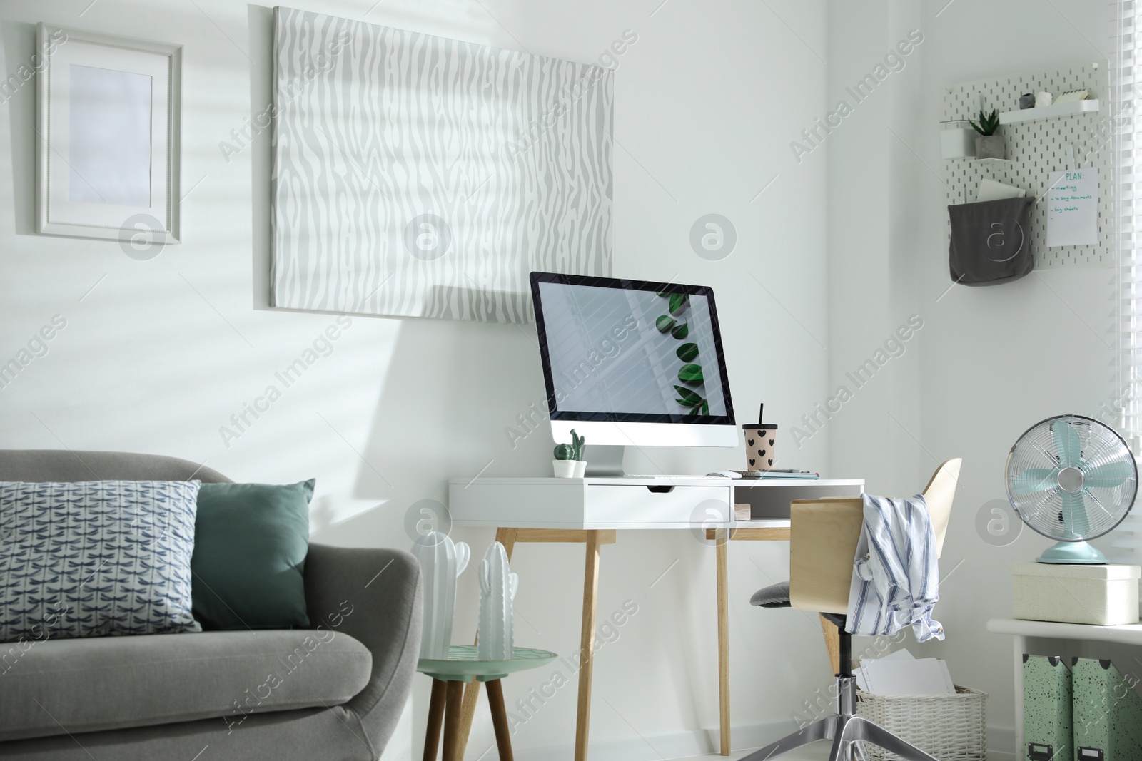 Photo of Comfortable office chair near desk with modern computer indoors