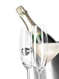 Empty glasses and metal bucket with bottle of champagne on white background