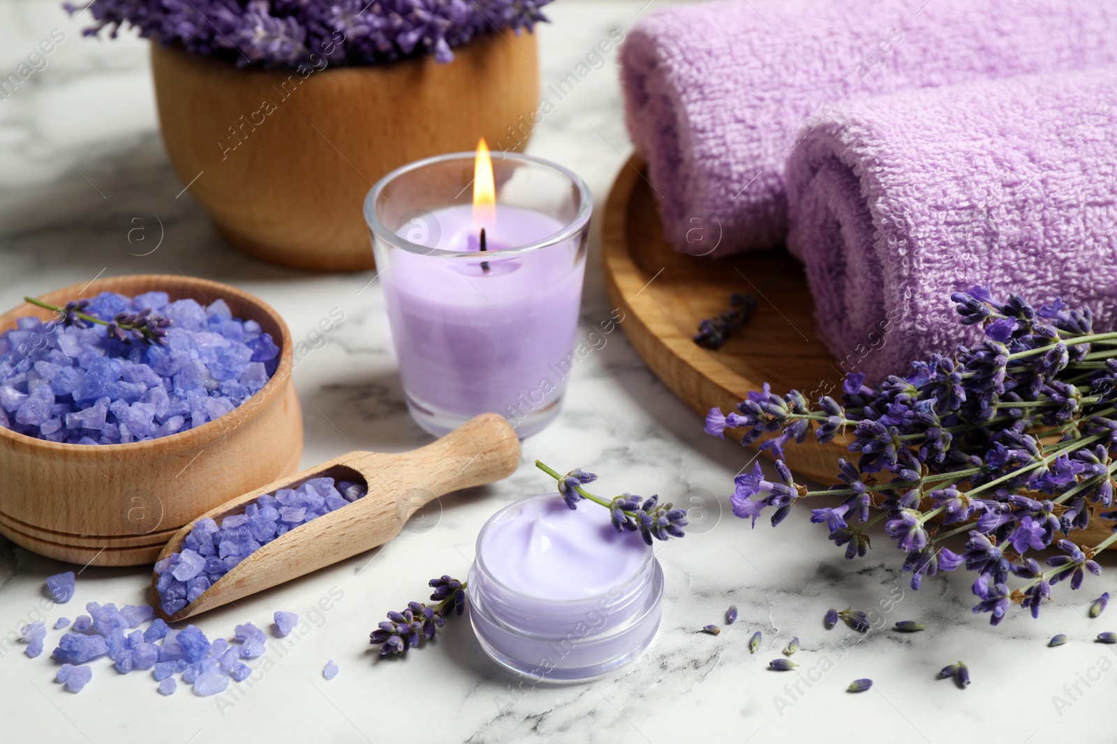 Photo of Cosmetic products and lavender flowers on white marble table