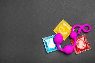 Photo of Anal balls and condoms on black background, top view with space for text. Sex game