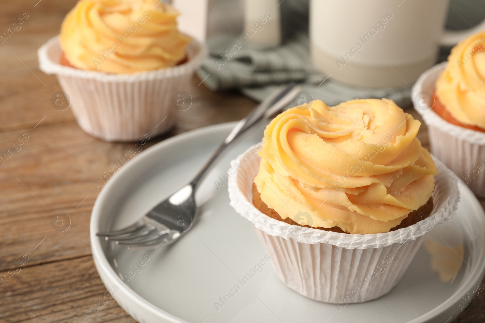 Photo of Tasty cupcakes with cream served on table, closeup