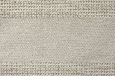 Texture of beige knitted fabric as background, top view