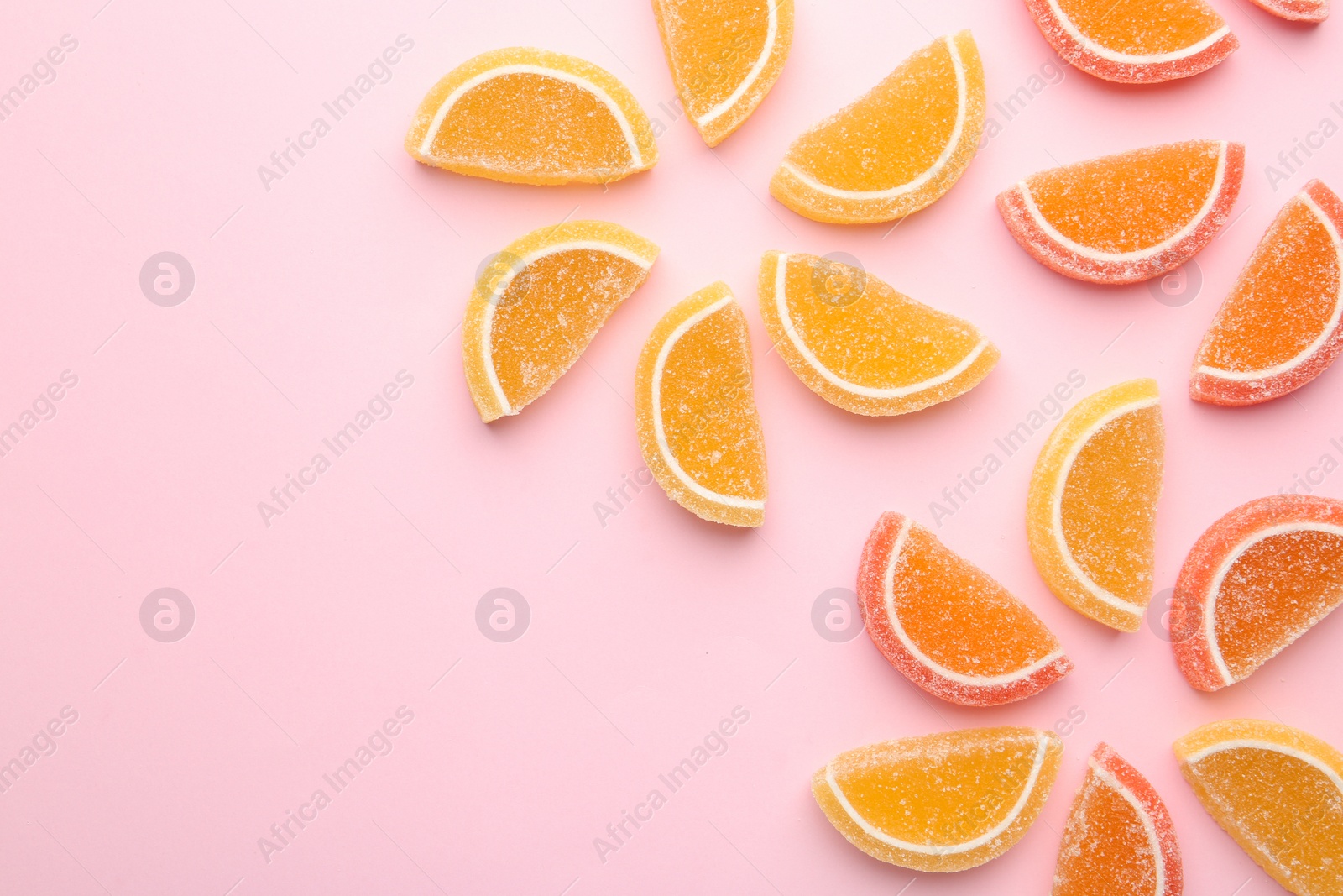 Photo of Flat lay composition with bright tasty jelly candies and space for text on color background