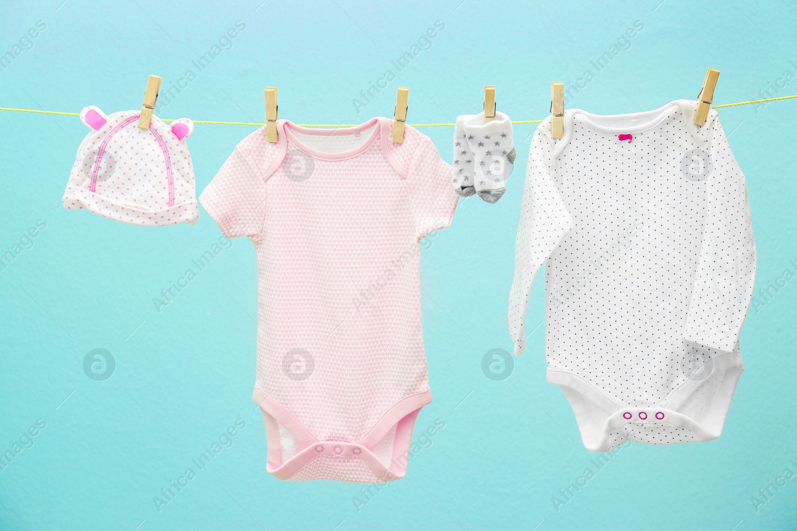 Photo of Children's clothes on laundry line against color background