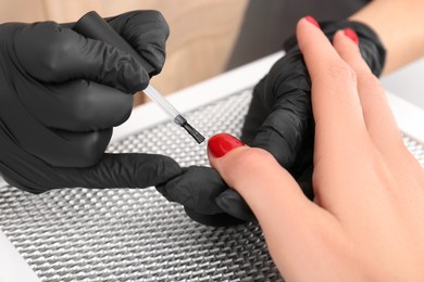 Photo of Professional manicurist working with client at table, closeup