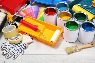 Cans of paint and decorator tools on wooden floor