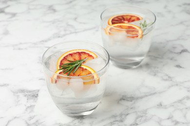Photo of Delicious refreshing drink with sicilian orange and rosemary on white marble table