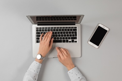 Photo of Woman using modern laptop at table, top view