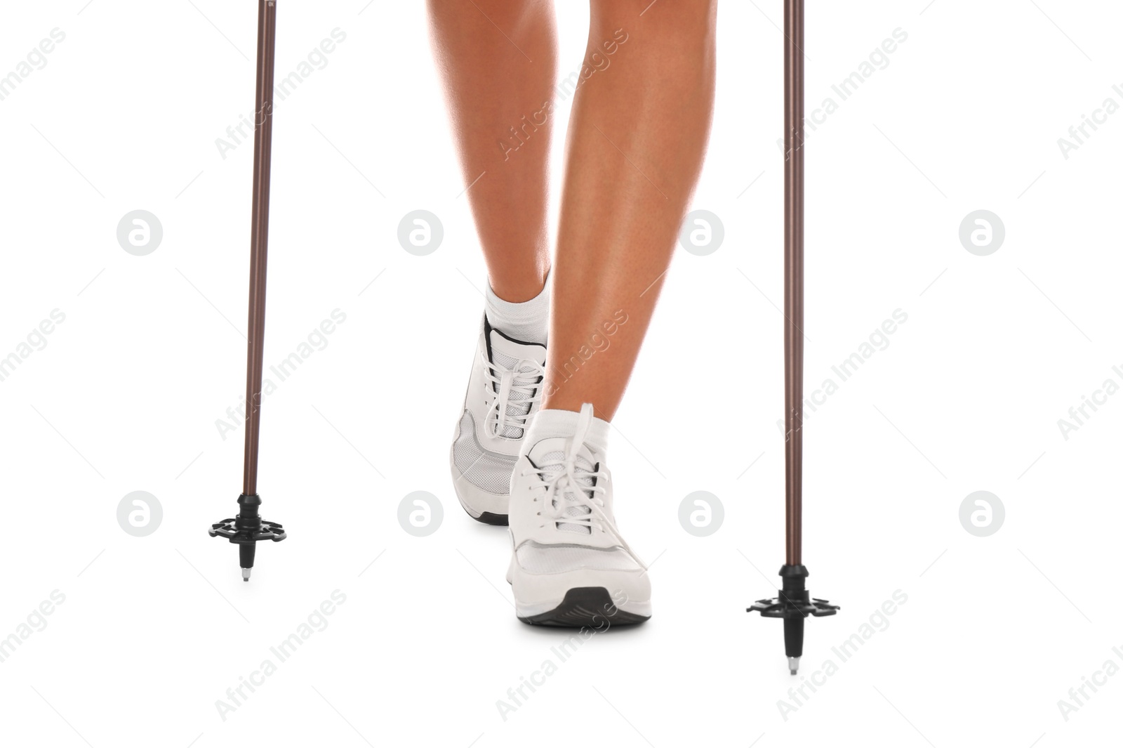 Photo of Woman wearing stylish shoes with trekking poles on white background, closeup