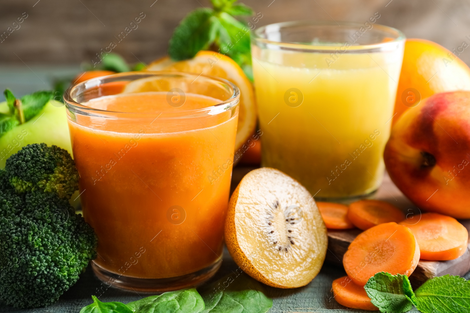 Photo of Glasses of delicious juices and fresh ingredients on table, closeup