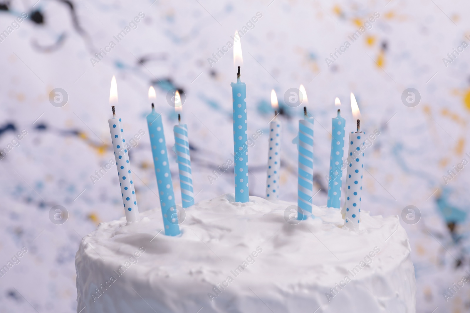 Photo of Delicious cake with cream and burning candles on color background, closeup