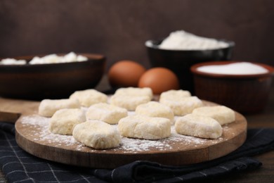 Making lazy dumplings. Board with cut dough and ingredients on wooden table, closeup