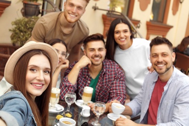 Photo of Happy people taking selfie at outdoor cafe