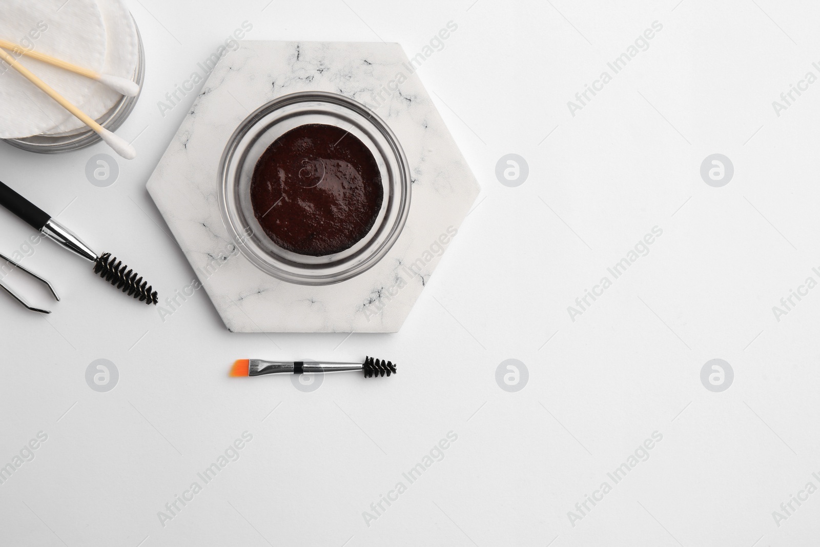 Photo of Flat lay composition with eyebrow henna and professional tools on white background, space for text