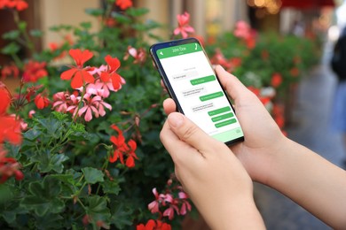 Woman texting via mobile phone outdoors, closeup. Device screen with messages