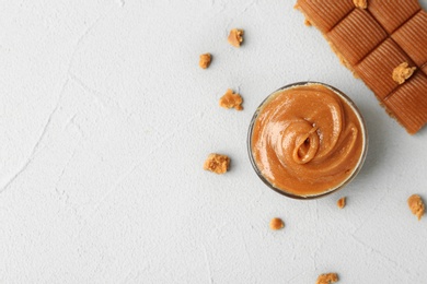 Photo of Gravy boat with caramel sauce and candies on table, top view