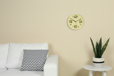 Photo of Living room interior with clock and space for text on wall. Time management