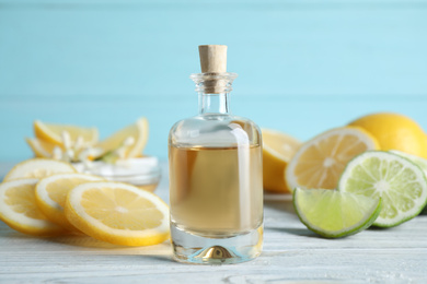 Photo of Citrus essential oil on white wooden table