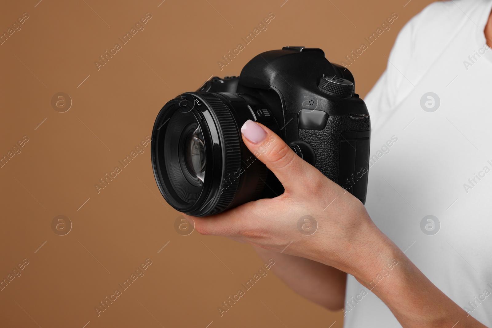 Photo of Photographer with camera on brown background, closeup. Space for text