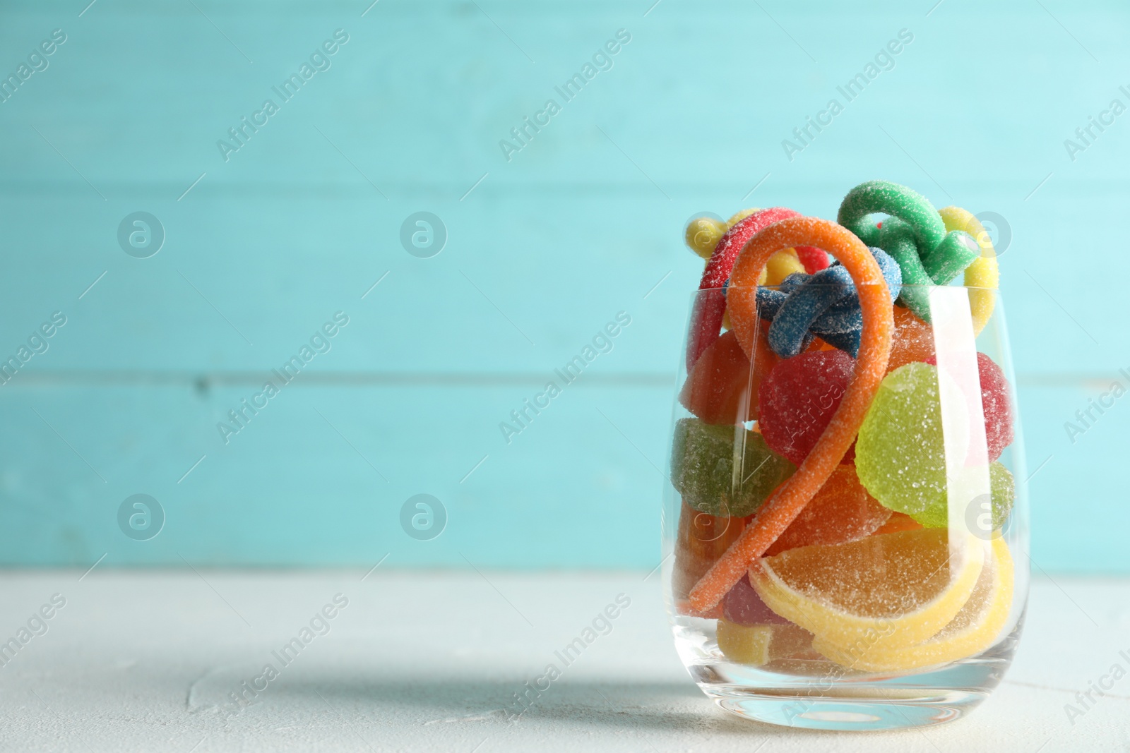 Photo of Delicious colorful candies on white table. Space for text