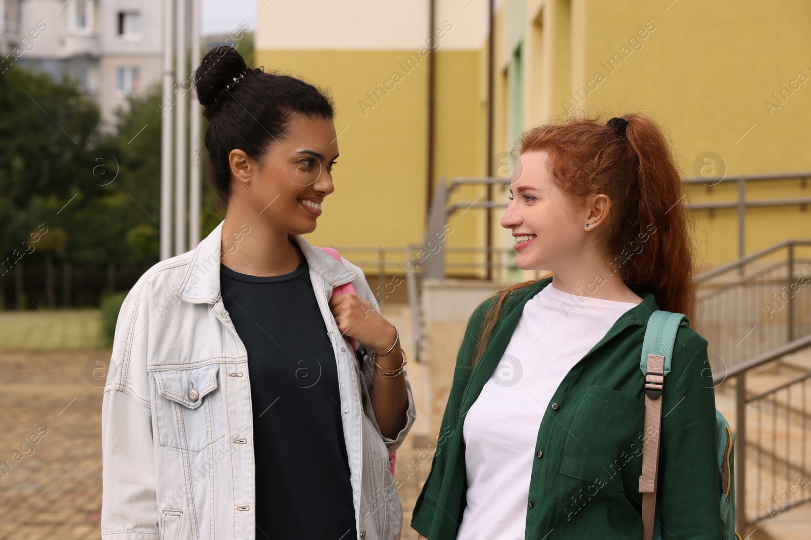 Photo of Happy young students spending time together outdoors