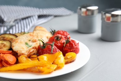 Delicious cooked chicken and vegetables on grey table, closeup. Healthy meals from air fryer