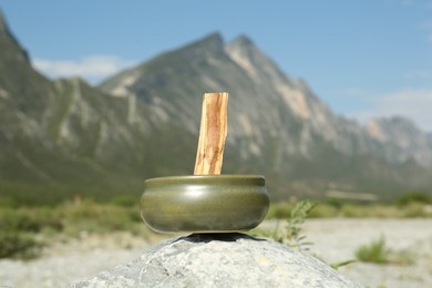 Photo of Palo santo stick on stone surface in high mountains