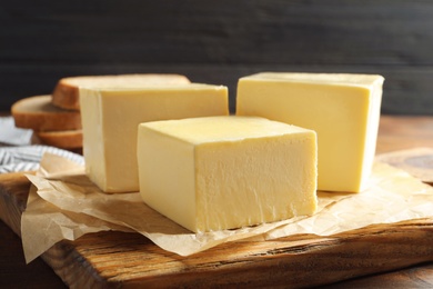 Wooden board with fresh butter on table