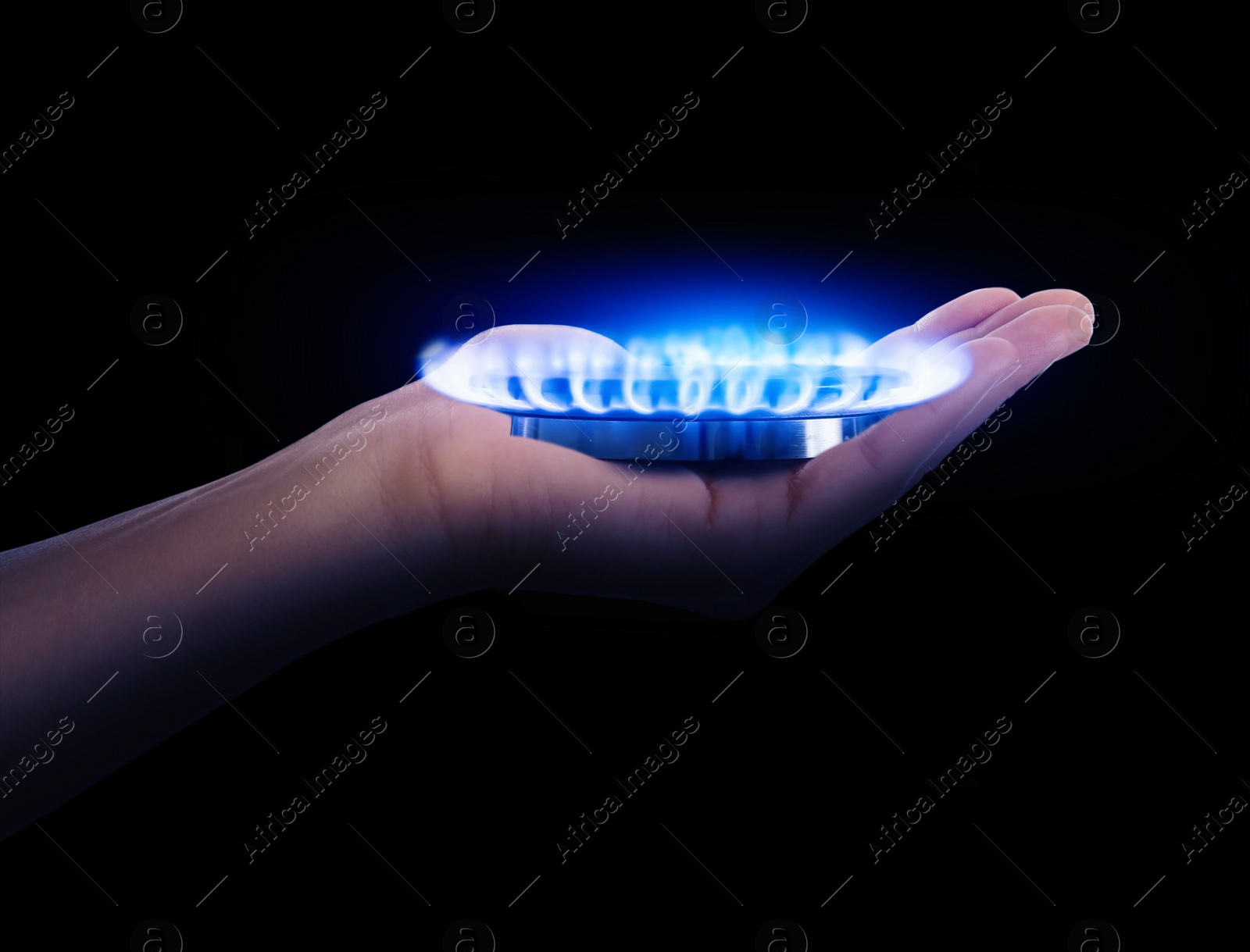 Image of Closeup view of woman holding gas burner with blue flame on black background