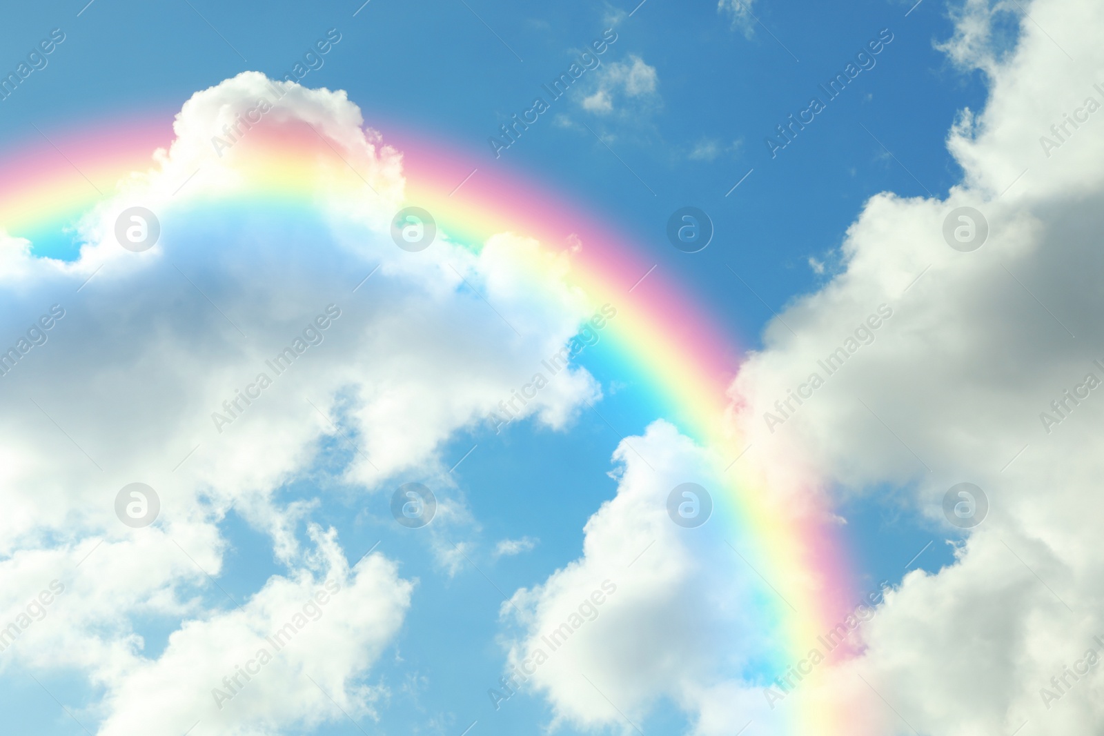 Image of Picturesque view of beautiful rainbow and blue sky on sunny day 