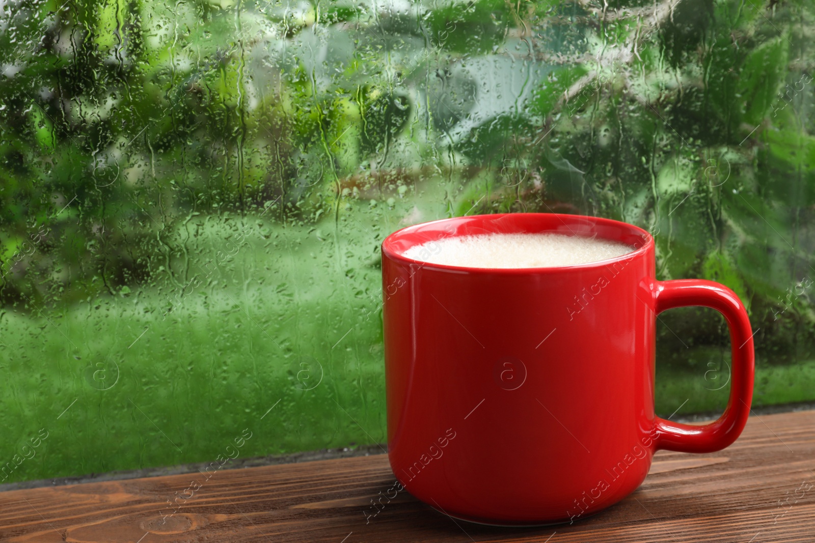 Photo of Cup of coffee on wooden windowsill, space for text. Rainy weather