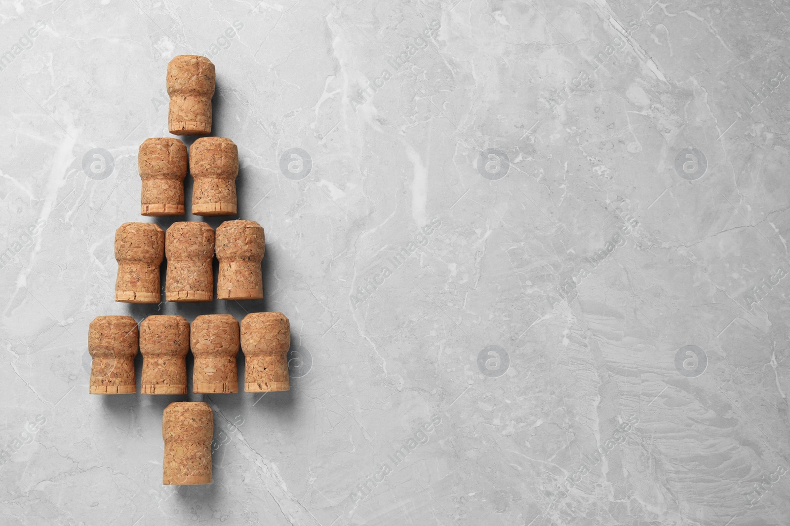 Photo of Christmas tree made of wine corks on light grey table, top view. Space for text