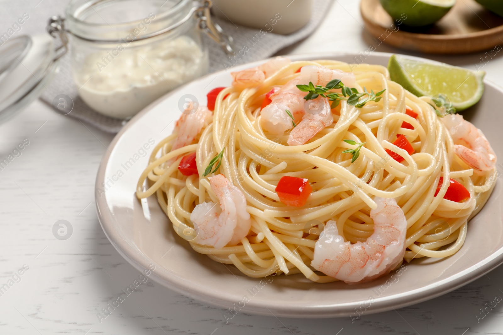 Photo of Plate with spaghetti and shrimps on table