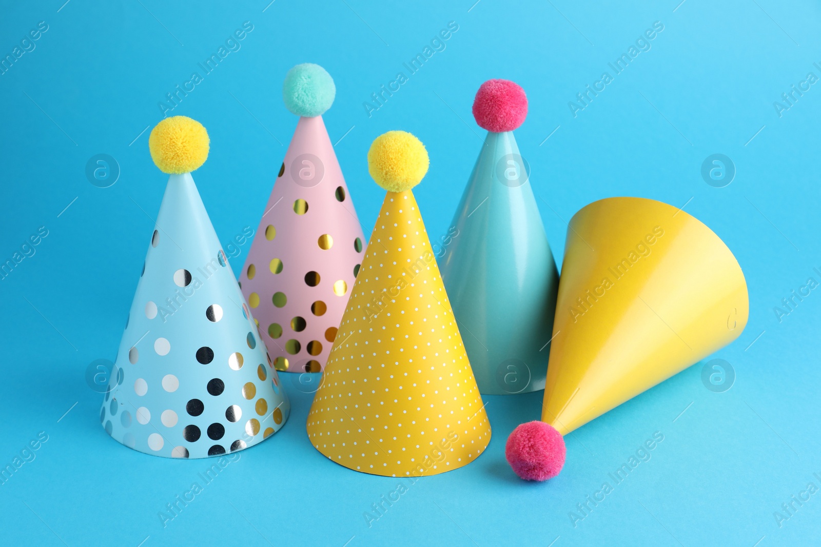 Photo of Colorful party hats on light blue background