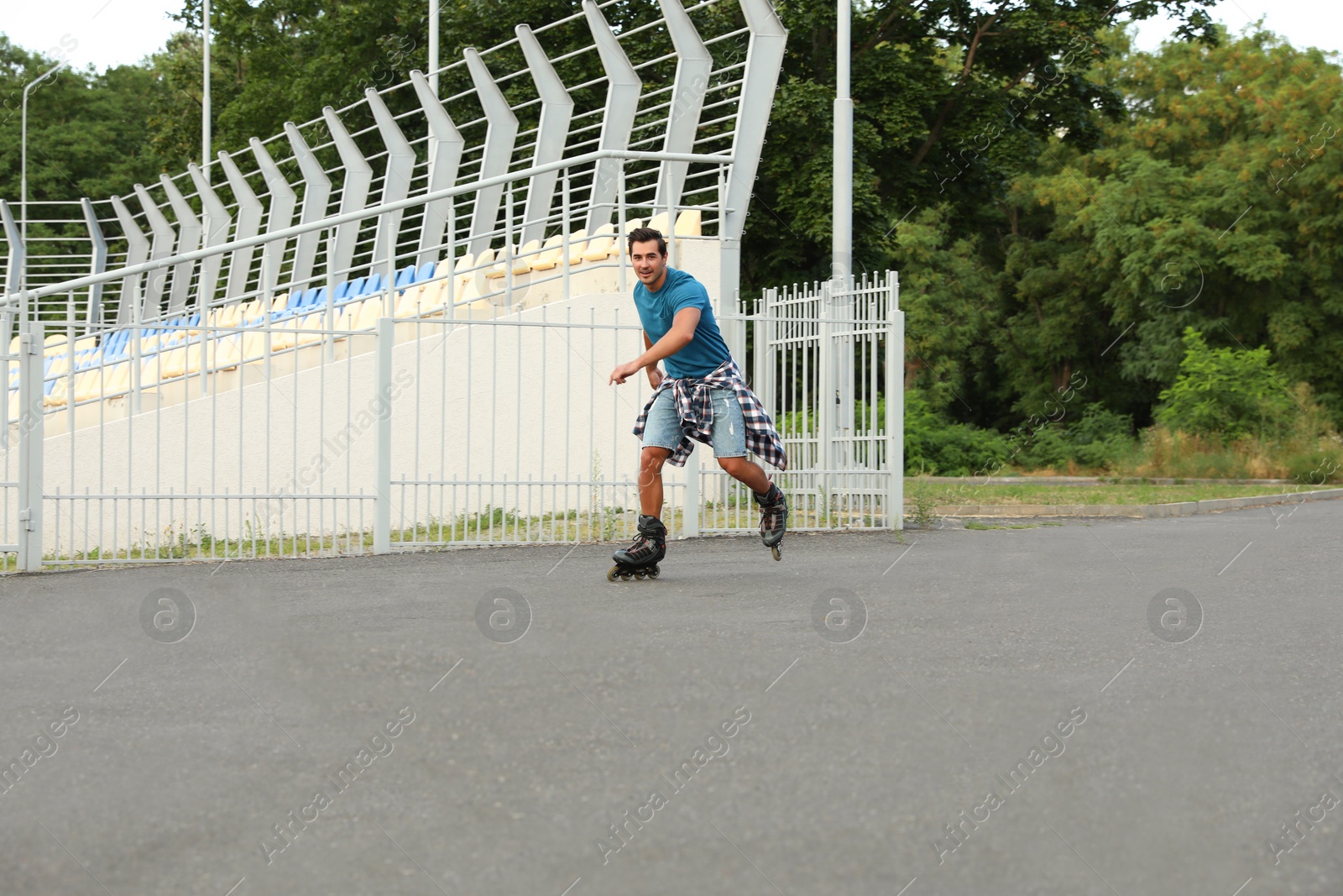 Photo of Handsome young man roller skating outdoors. Recreational activity