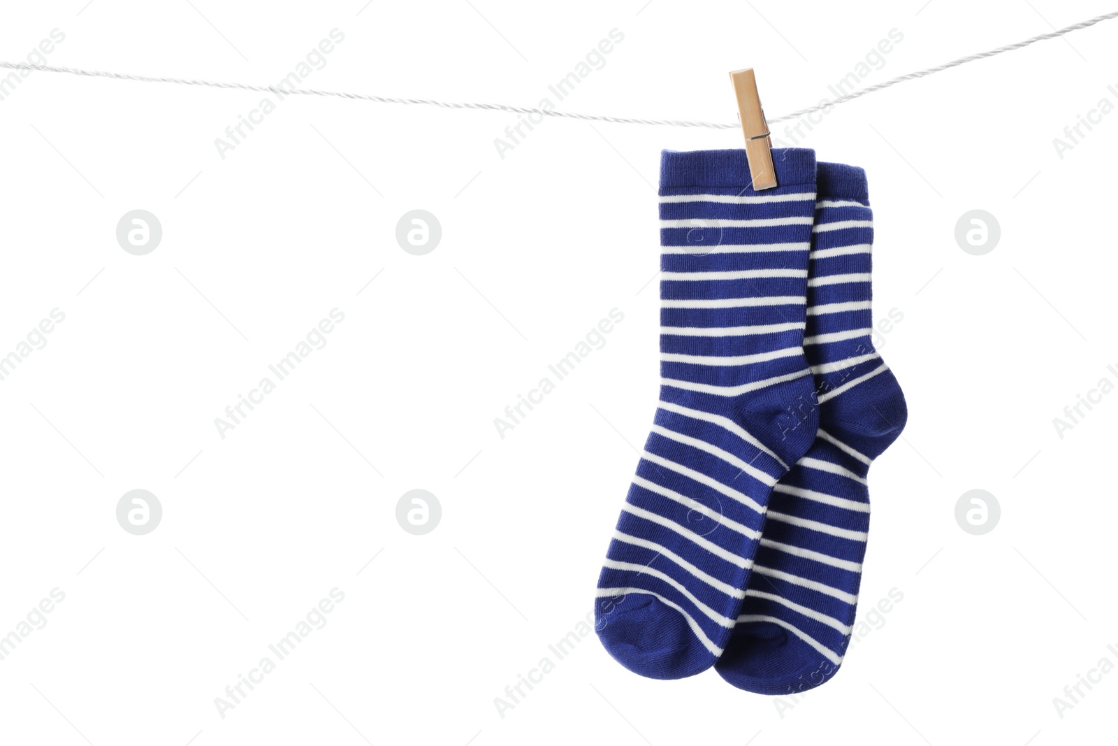 Photo of Cute child socks on laundry line against white background