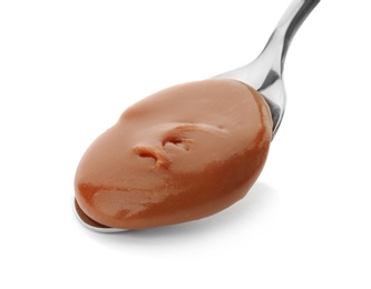 Spoon with delicious caramel on white background