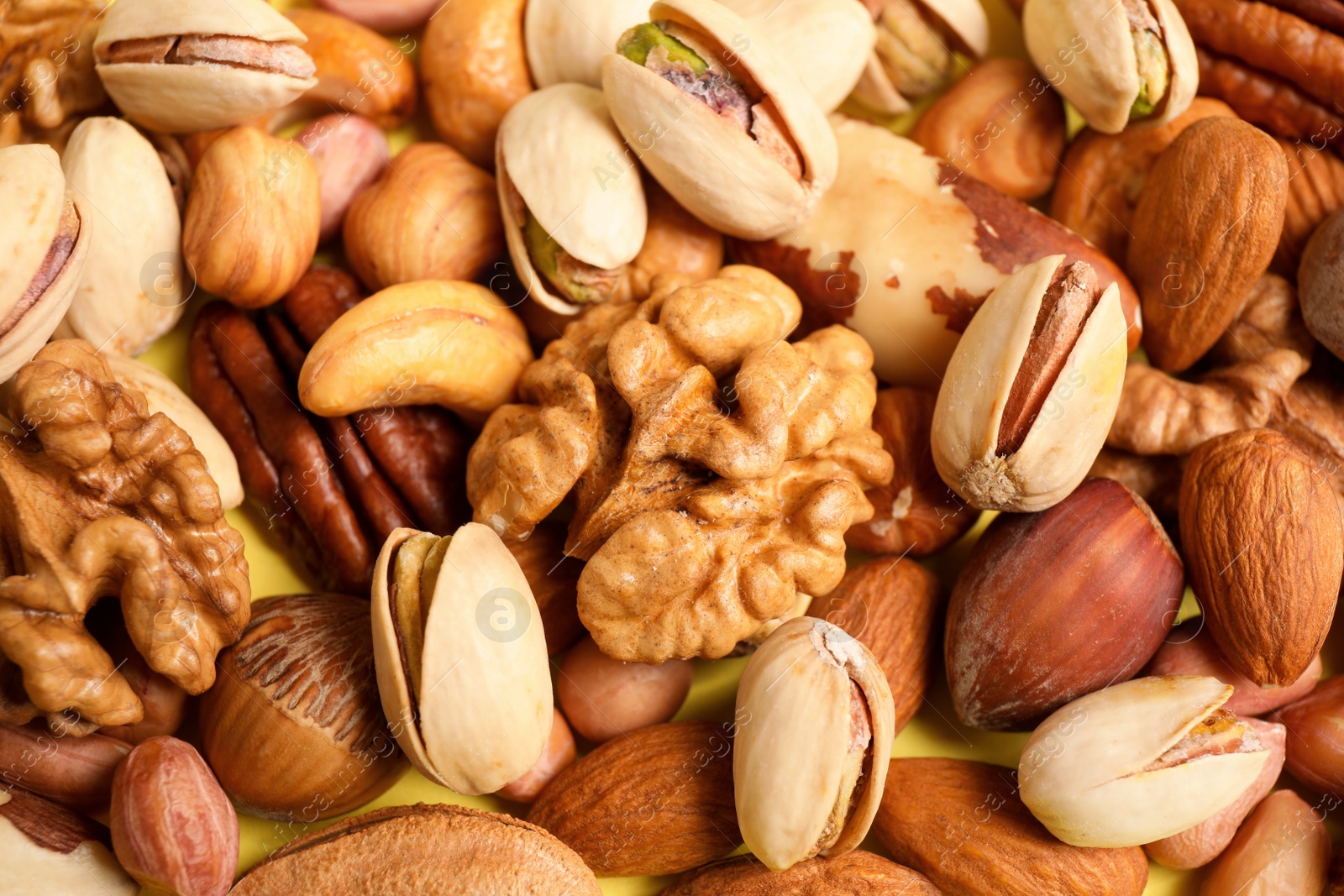 Photo of Different delicious nuts as background, closeup view