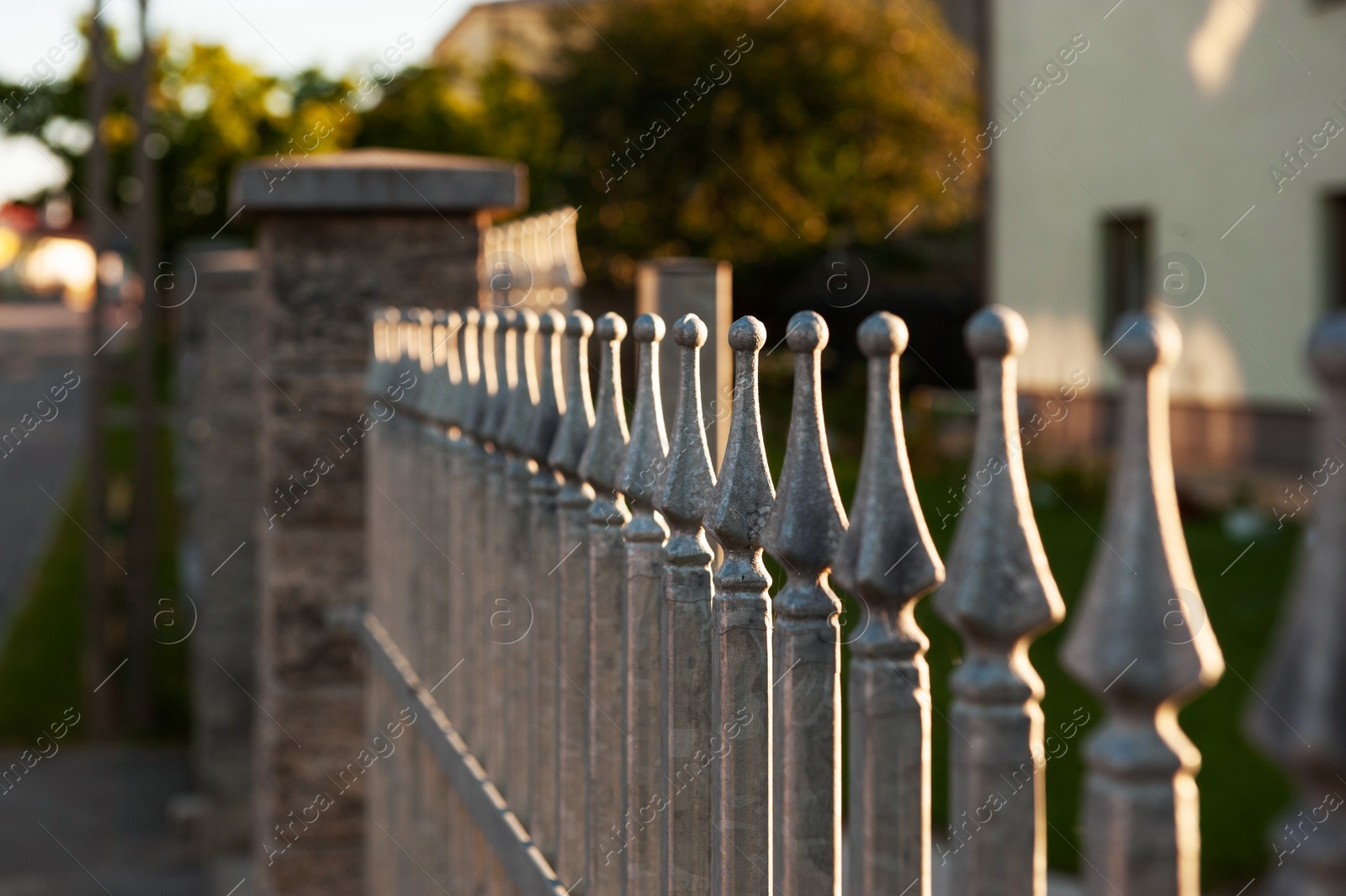 Photo of Beautiful iron fence on sunny day outdoors, closeup