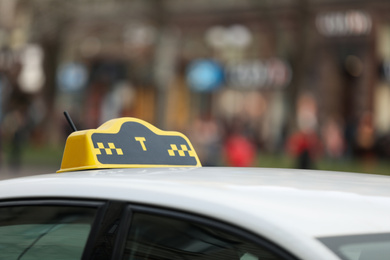 Photo of Taxi cab with yellow sign on city street, closeup
