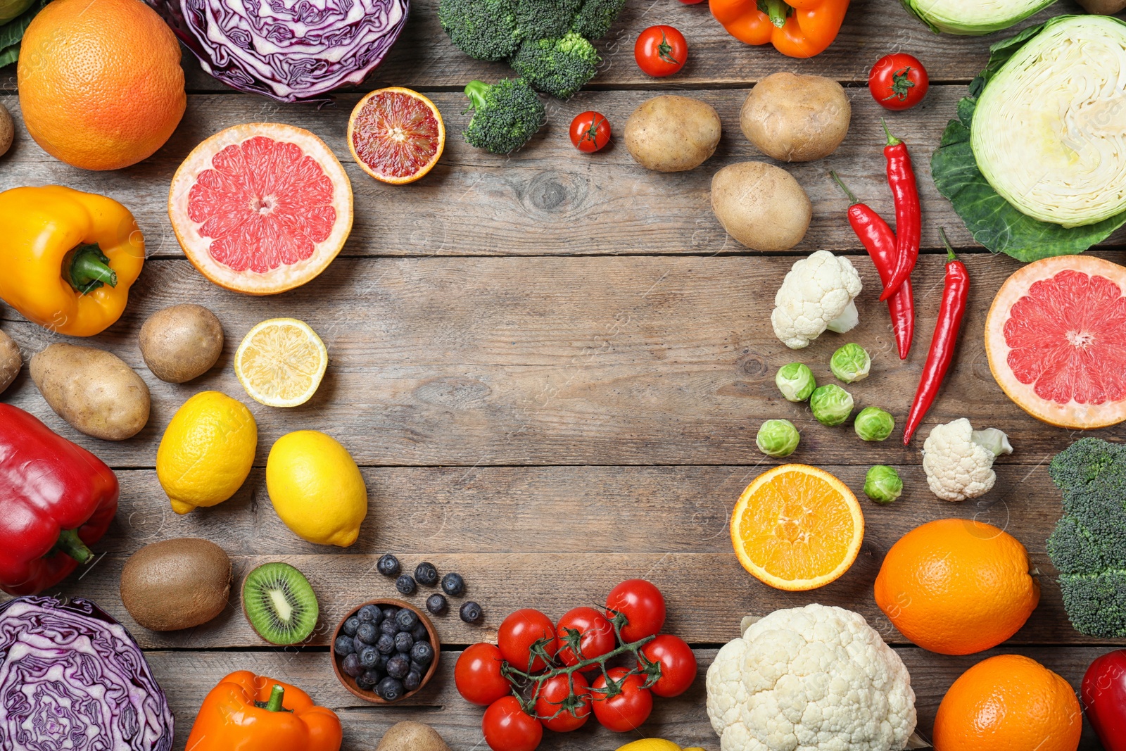 Photo of Different products rich in vitamin C on wooden table, flat lay. Space for text