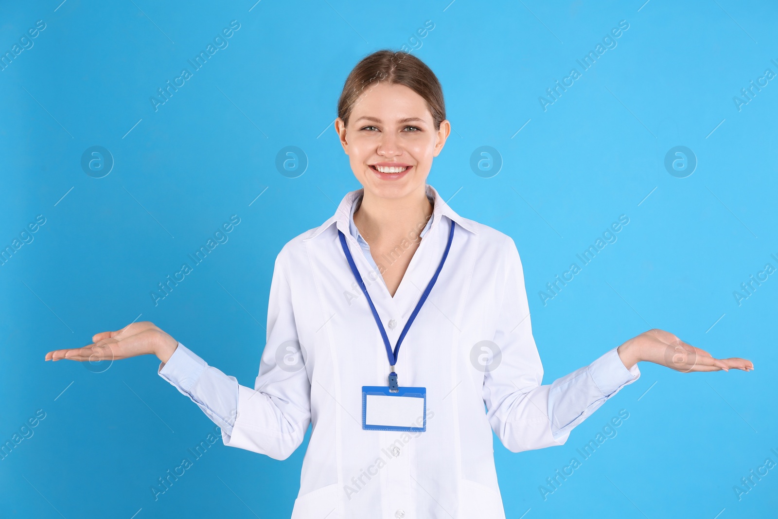 Photo of Portrait of young doctor on blue background. Medical service