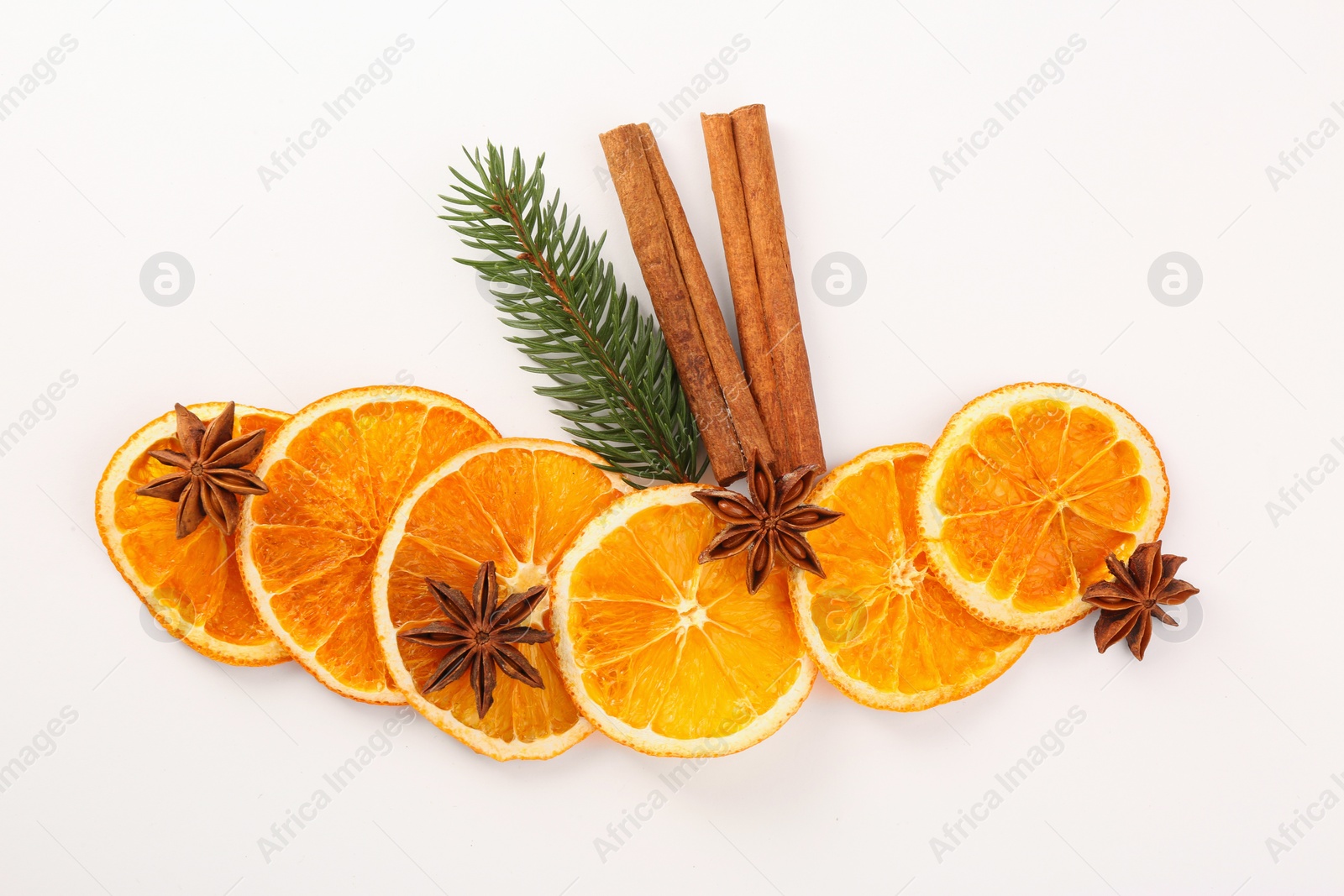 Photo of Dry orange slices, cinnamon sticks, fir branch and anise stars on white background, flat lay