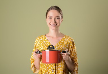 Photo of Happy woman with pot on olive background