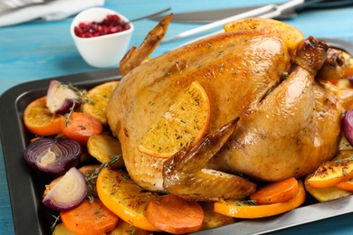 Delicious chicken with oranges and vegetables in baking pan, closeup