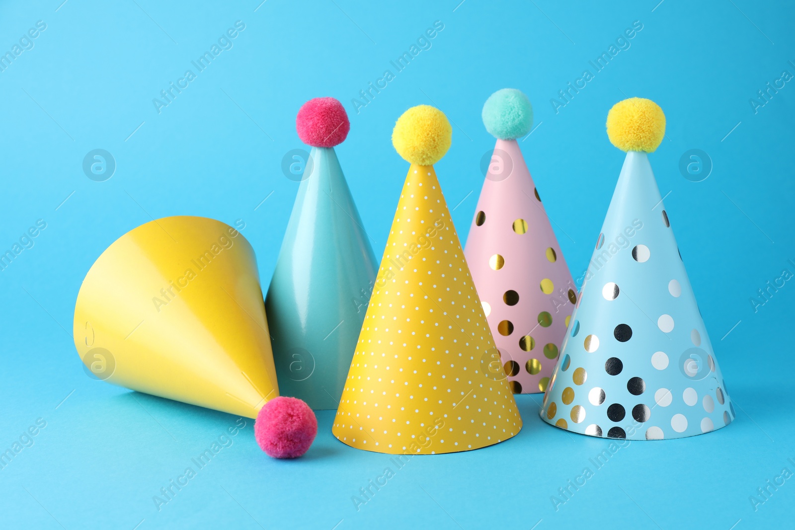 Photo of Colorful party hats on light blue background