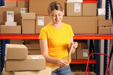 Post office worker with adhesive paper bag indoors